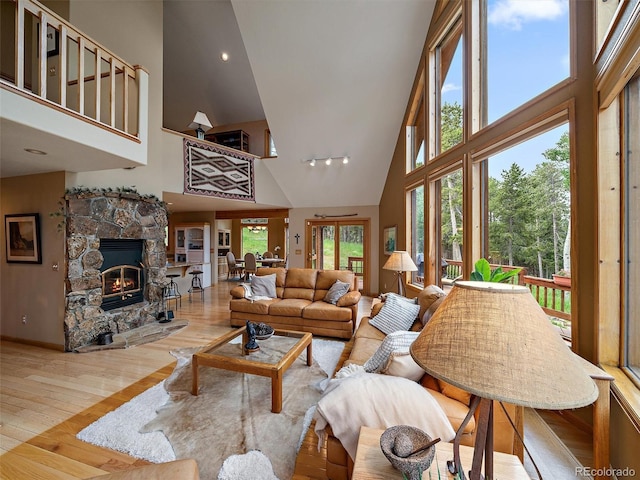 13094 Molly Dr, Conifer, CO 80433 - living area with high vaulted ceiling, wood-type flooring, and a stone fireplace