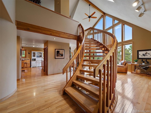 13094 Molly Dr, Conifer, CO 80433 - staircase with rail lighting, hardwood / wood-style floors, high vaulted ceiling, and ceiling fan