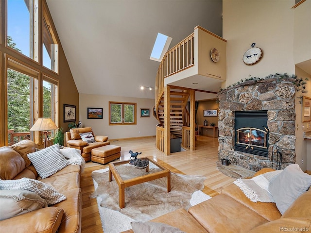 13094 Molly Dr, Conifer, CO 80433 - living room with high vaulted ceiling, a skylight, wood finished floors, and stairs