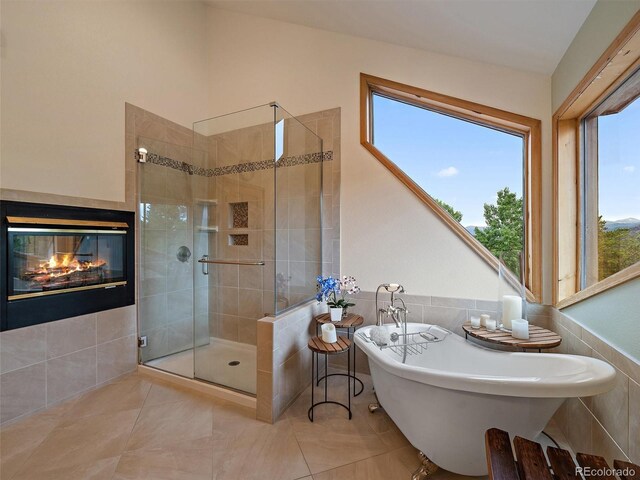 13094 Molly Dr, Conifer, CO 80433 - full bathroom featuring a stall shower, a soaking tub, tile patterned floors, a tile fireplace, and tile walls