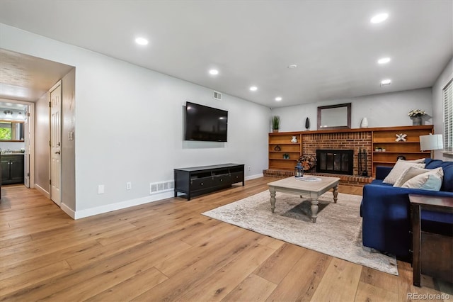 living area with light wood finished floors, recessed lighting, baseboards, and a fireplace