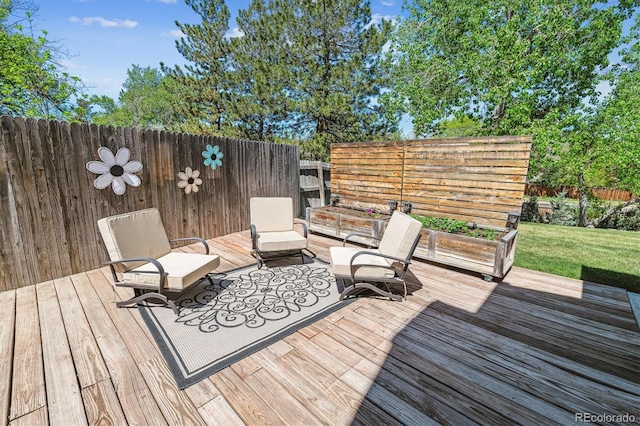 wooden terrace featuring a fenced backyard and an outdoor living space