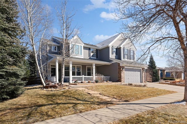 traditional home with concrete driveway, an attached garage, a front yard, a porch, and brick siding