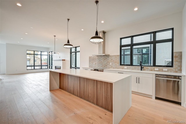 kitchen featuring white cabinetry, stainless steel appliances, island exhaust hood, and a kitchen island