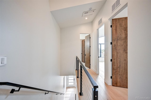 stairway with hardwood / wood-style floors and lofted ceiling