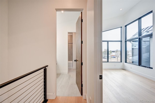 hallway with vaulted ceiling and light hardwood / wood-style floors