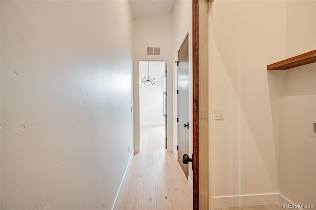 hall featuring light hardwood / wood-style floors and a high ceiling