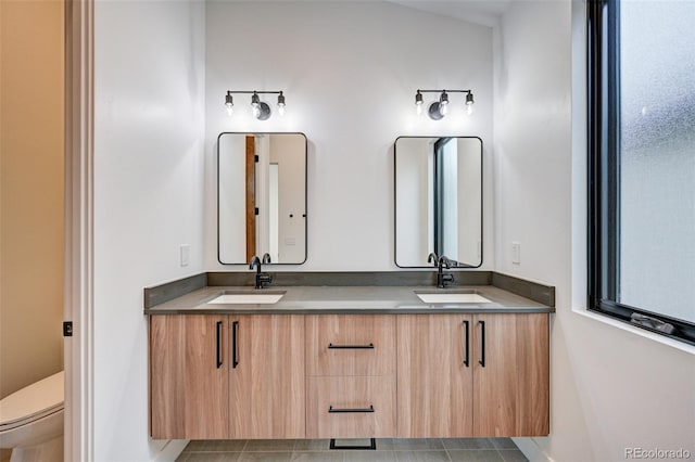 bathroom with vanity, tile patterned flooring, toilet, and lofted ceiling