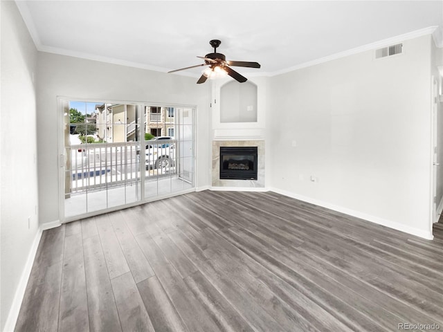 unfurnished living room featuring crown molding, hardwood / wood-style flooring, a tile fireplace, and ceiling fan