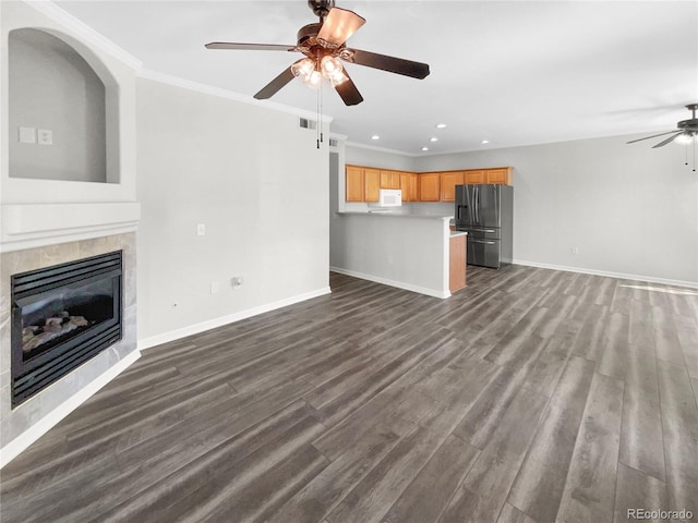 unfurnished living room with a fireplace, ornamental molding, ceiling fan, and hardwood / wood-style floors