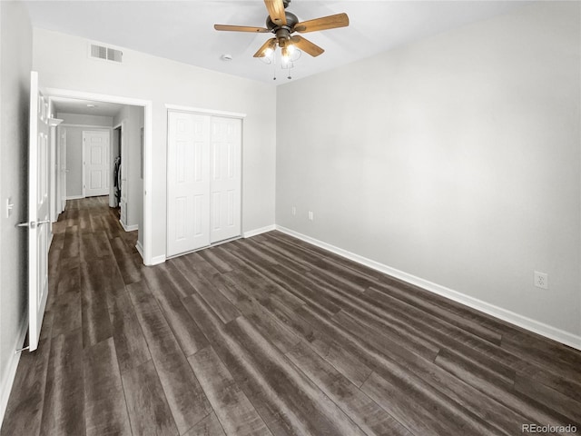 unfurnished bedroom with dark wood-type flooring, a closet, and ceiling fan