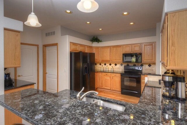 698 Larimer Creek Dr, Monument, CO 80132 - kitchen with black appliances, a sink, backsplash, recessed lighting, and dark stone countertops