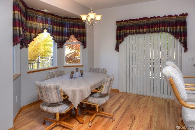 698 Larimer Creek Dr, Monument, CO 80132 - dining area with wood finished floors, a chandelier, and baseboards