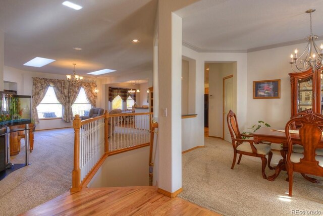 698 Larimer Creek Dr, Monument, CO 80132 - dining space with a chandelier, a skylight, carpet floors, baseboards, and wood finished floors