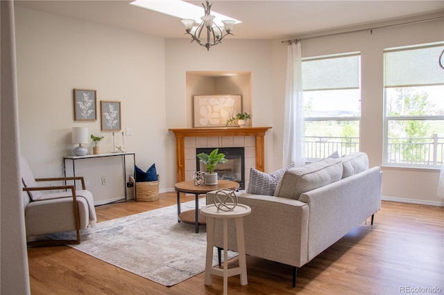 698 Larimer Creek Dr, Monument, CO 80132 - living area with a chandelier, wood finished floors, and a tile fireplace