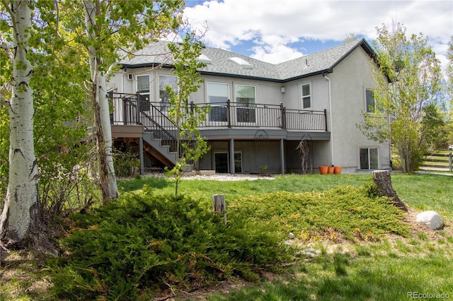 698 Larimer Creek Dr, Monument, CO 80132 - rear view of house featuring a wooden deck, stairs, a yard, stucco siding, and a shingled roof