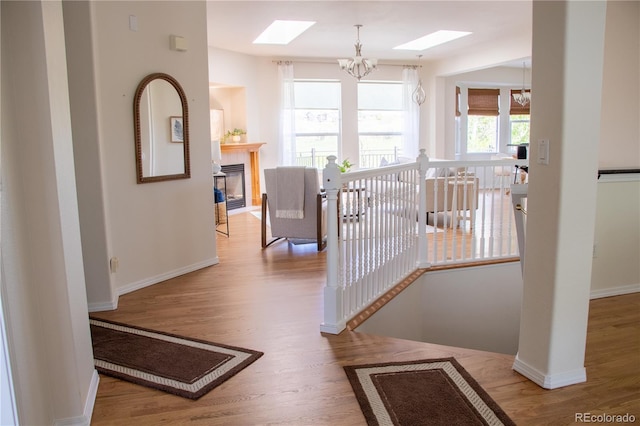 698 Larimer Creek Dr, Monument, CO 80132 - hall with a skylight, a chandelier, wood finished floors, and an upstairs landing