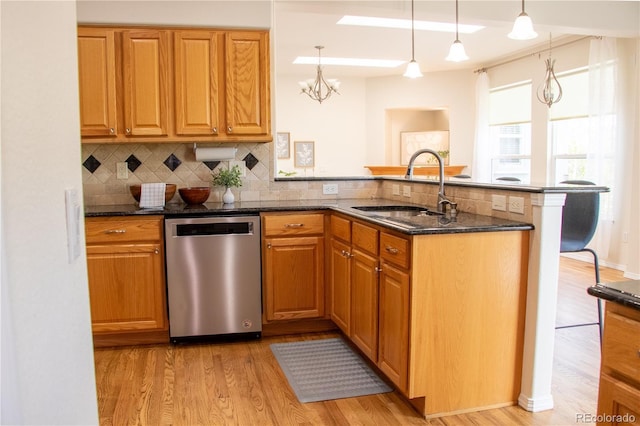 698 Larimer Creek Dr, Monument, CO 80132 - kitchen featuring stainless steel dishwasher, a peninsula, light wood finished floors, and decorative backsplash