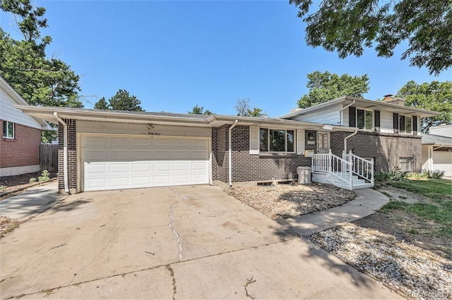 1533 S Jamaica St, Aurora, CO 80012 - tri-level home with brick siding, a garage, and concrete driveway