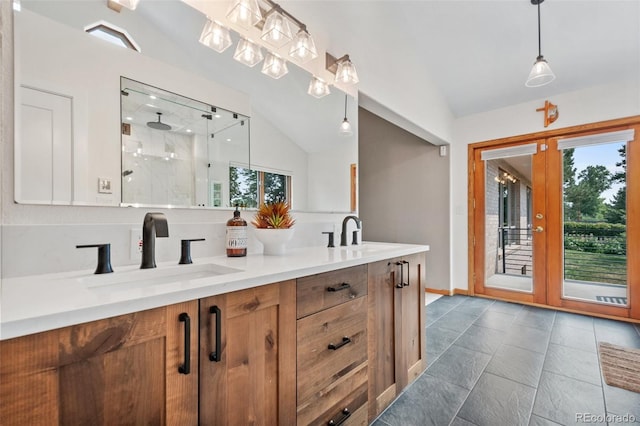 full bath featuring a shower stall, lofted ceiling, double vanity, and a sink
