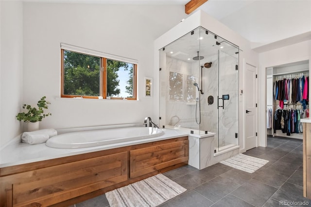 bathroom with a spacious closet, a bath, beam ceiling, and a marble finish shower