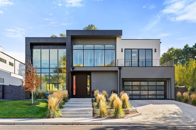 modern home featuring a garage, driveway, and a balcony