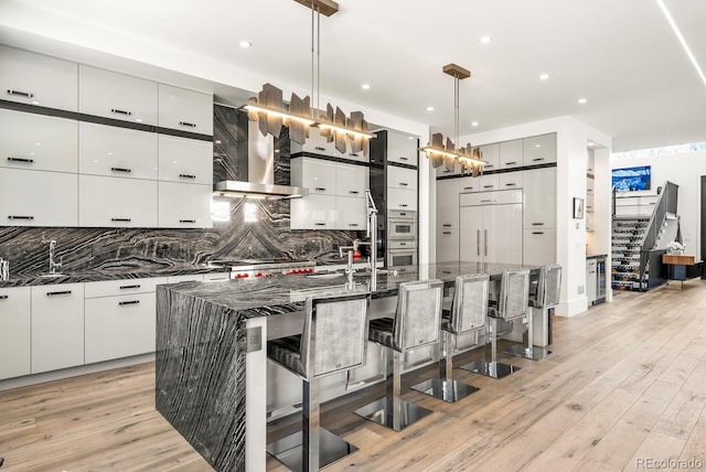 kitchen with tasteful backsplash, paneled refrigerator, modern cabinets, and a kitchen breakfast bar