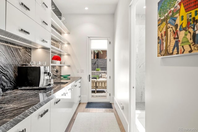 interior space with white cabinets, recessed lighting, light wood-style flooring, and open shelves