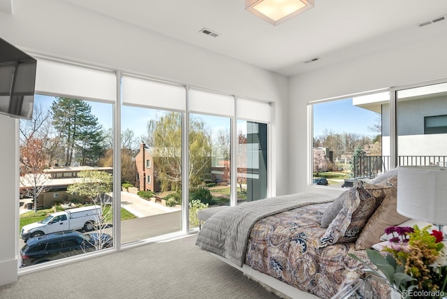 bedroom with carpet flooring, visible vents, and access to exterior
