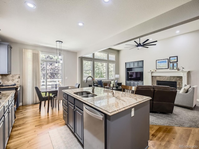 14310 Kalamath St, Westminster, CO 80023 - kitchen featuring stainless steel dishwasher, a fireplace, a center island with sink, light wood-type flooring, and recessed lighting