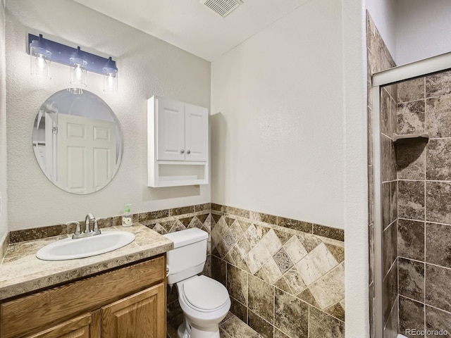 14310 Kalamath St, Westminster, CO 80023 - bathroom featuring a stall shower, vanity, tile walls, and wainscoting