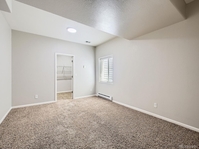 14310 Kalamath St, Westminster, CO 80023 - unfurnished bedroom featuring baseboard heating, light carpet, a walk in closet, a textured ceiling, and a closet