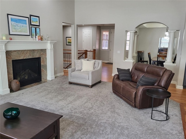 14310 Kalamath St, Westminster, CO 80023 - living room featuring decorative columns, arched walkways, a premium fireplace, and wood finished floors