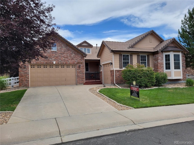 14310 Kalamath St, Westminster, CO 80023 - view of front of property with an attached garage, brick siding, concrete driveway, and a tiled roof