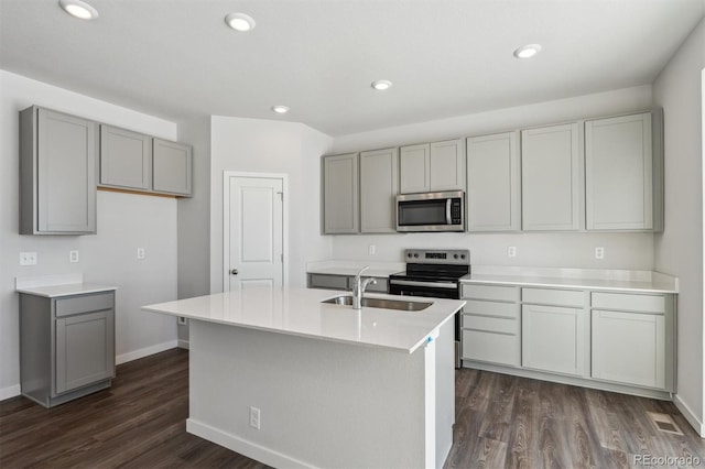 kitchen with appliances with stainless steel finishes, a kitchen island with sink, gray cabinetry, and sink