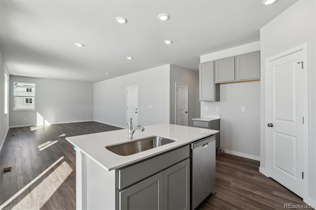 kitchen featuring sink, dark hardwood / wood-style floors, gray cabinets, an island with sink, and dishwasher