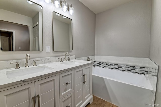 bathroom with a tub to relax in, hardwood / wood-style floors, and vanity