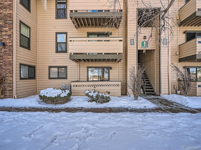 snow covered property with central AC unit