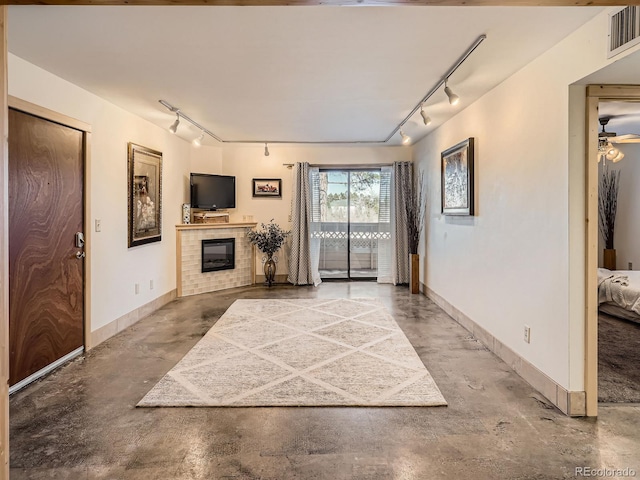 living room featuring track lighting and concrete floors