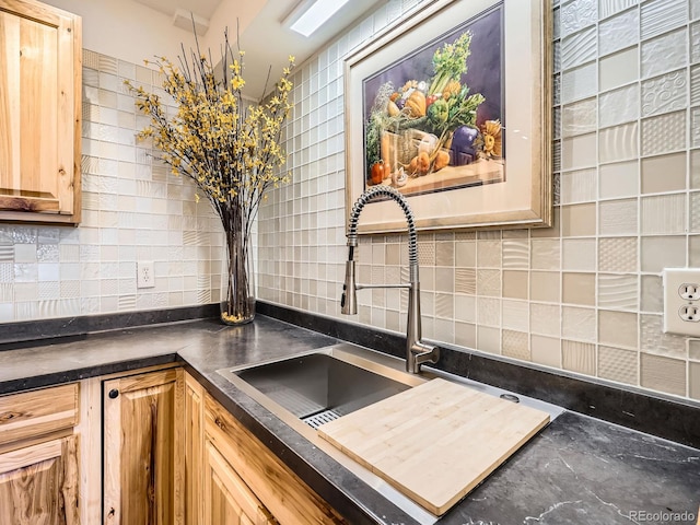 kitchen featuring light brown cabinetry, sink, and backsplash