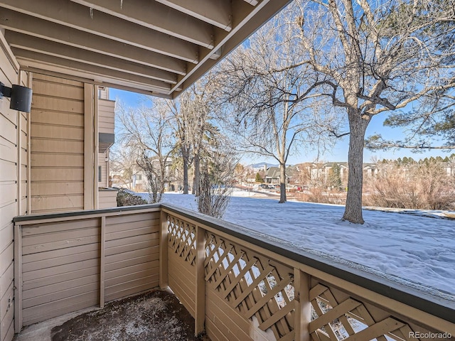 view of snow covered back of property