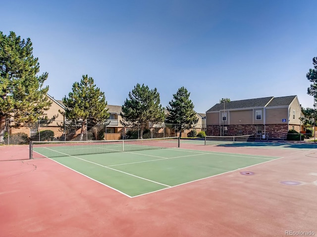 view of tennis court with basketball hoop