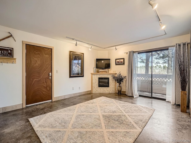 400 Zang St Unit 1-105, Lakewood, CO 80228 - unfurnished living room with track lighting, finished concrete floors, and a tiled fireplace