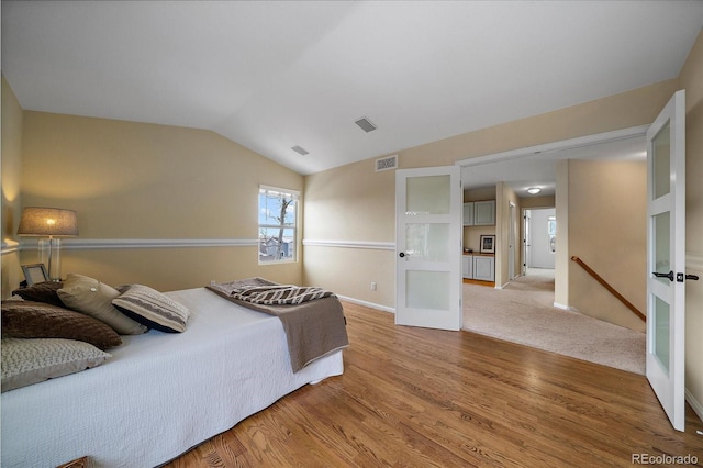 bedroom with wood-type flooring and lofted ceiling