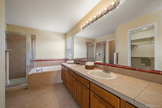 bathroom with independent shower and bath, tile patterned floors, and vanity