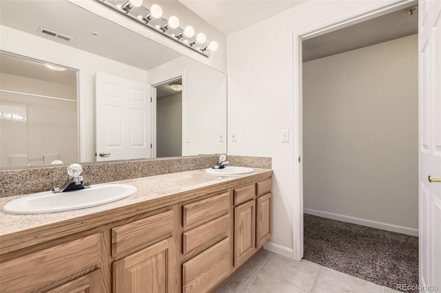 bathroom featuring tile patterned flooring, a shower, and vanity