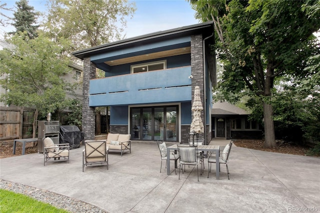 2143 S Downing St, Denver, CO 80210 - back of property featuring stone siding, a patio area, and a balcony