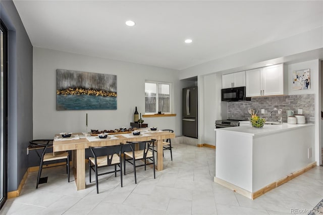 2143 S Downing St, Denver, CO 80210 - kitchen featuring appliances with stainless steel finishes, white cabinetry, light countertops, tasteful backsplash, and recessed lighting