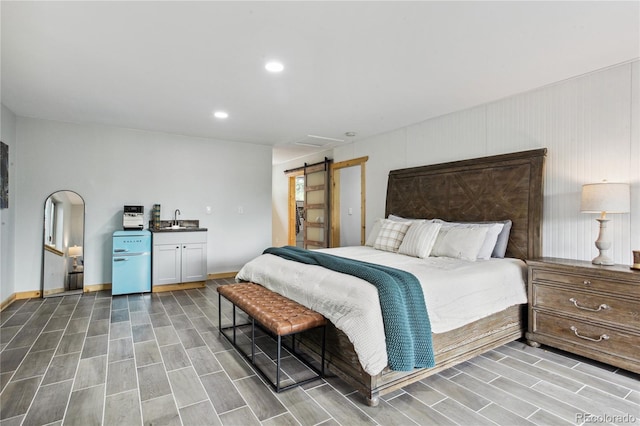 2143 S Downing St, Denver, CO 80210 - bedroom with wood tiled floors, a barn door, and recessed lighting