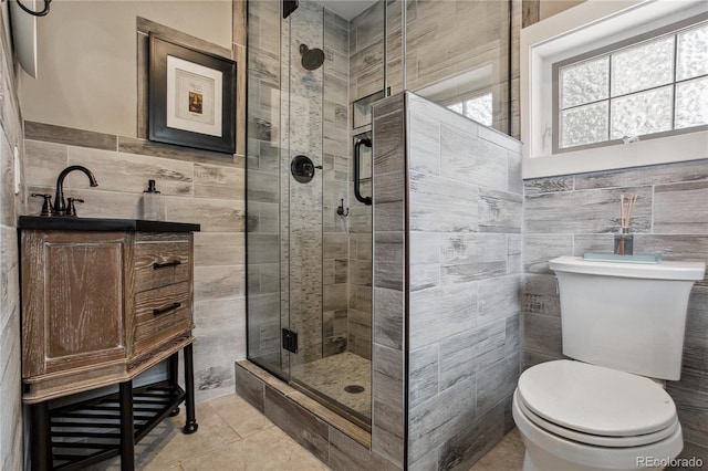 2143 S Downing St, Denver, CO 80210 - full bathroom with tile walls, a shower stall, tile patterned floors, vanity, and a wainscoted wall